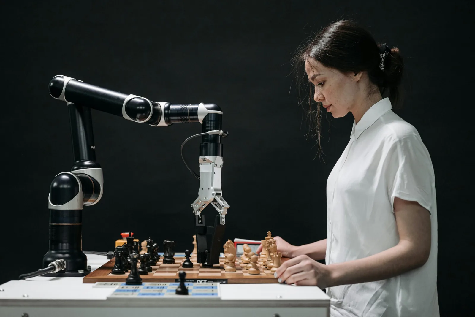 Femme jouant aux échecs contre un bras robotisé