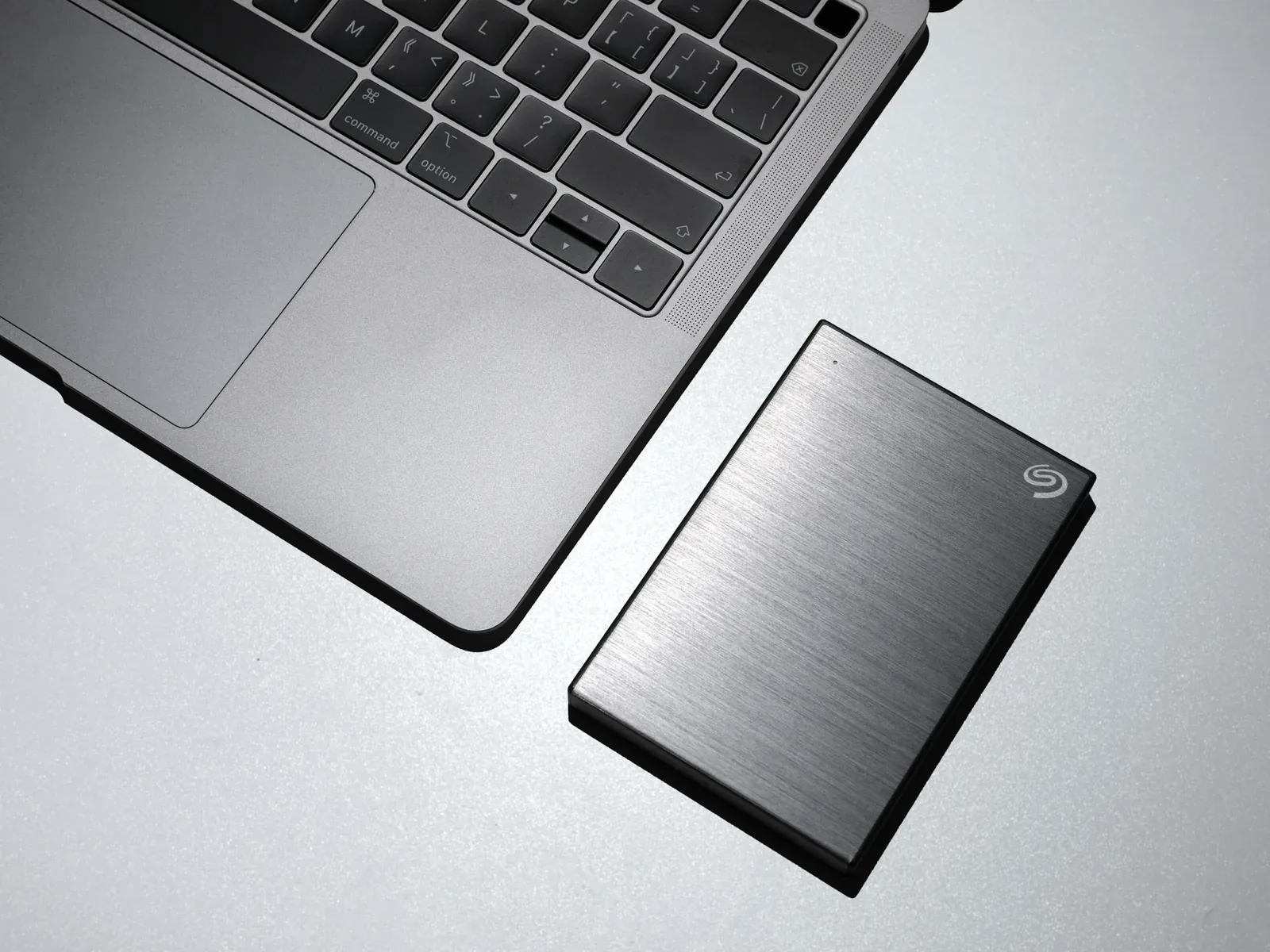 Disque dur externe posé à côté d’un ordinateur portable