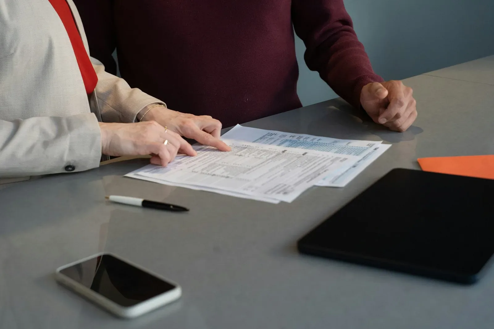 Deux personnes relisent des documents à une table de réunion